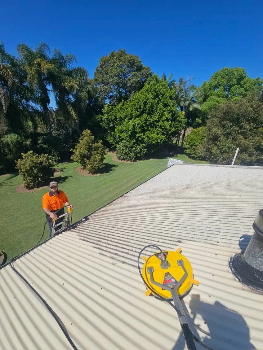 Danny beside a roof with surface-cleaning equipment